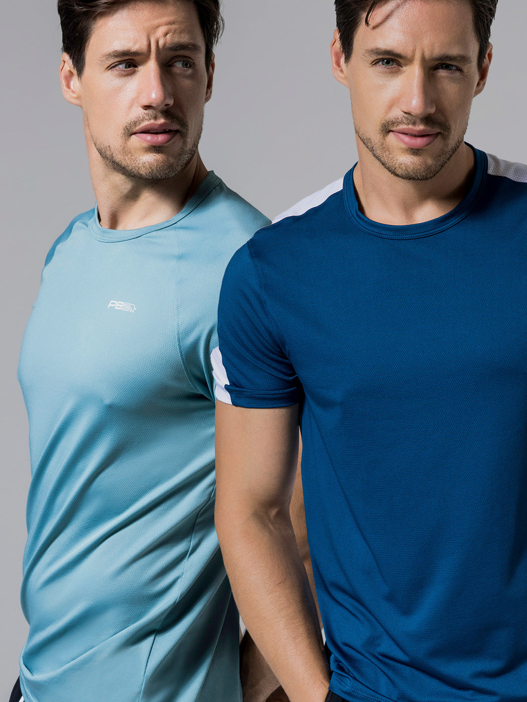 Two models wearing PB5 activewear, one in an arctic core performance tee and the other in an astral blue core vented tee, posing against a neutral gray background.