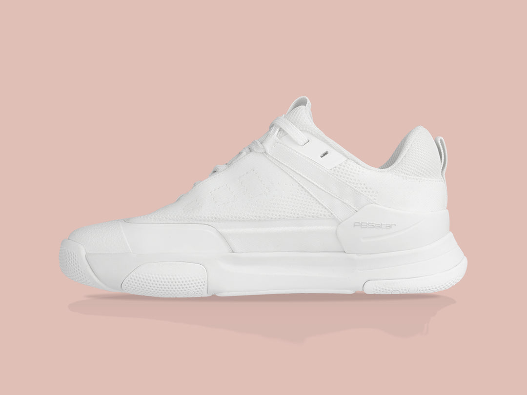 Side view of white PB5star Court2 performance sneaker featuring breathable mesh upper, durable sole with hexagonal grip pattern, and modern design.