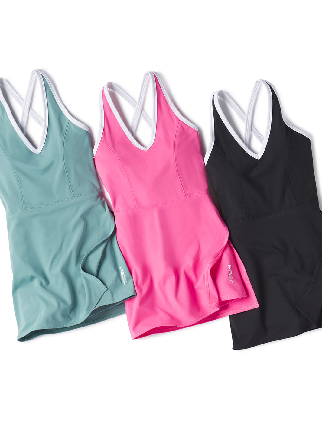 Three PB5star court dresses in arctic blue, pink, and black, each with white trim and crossed straps on the back, laid side-by-side on a white background.