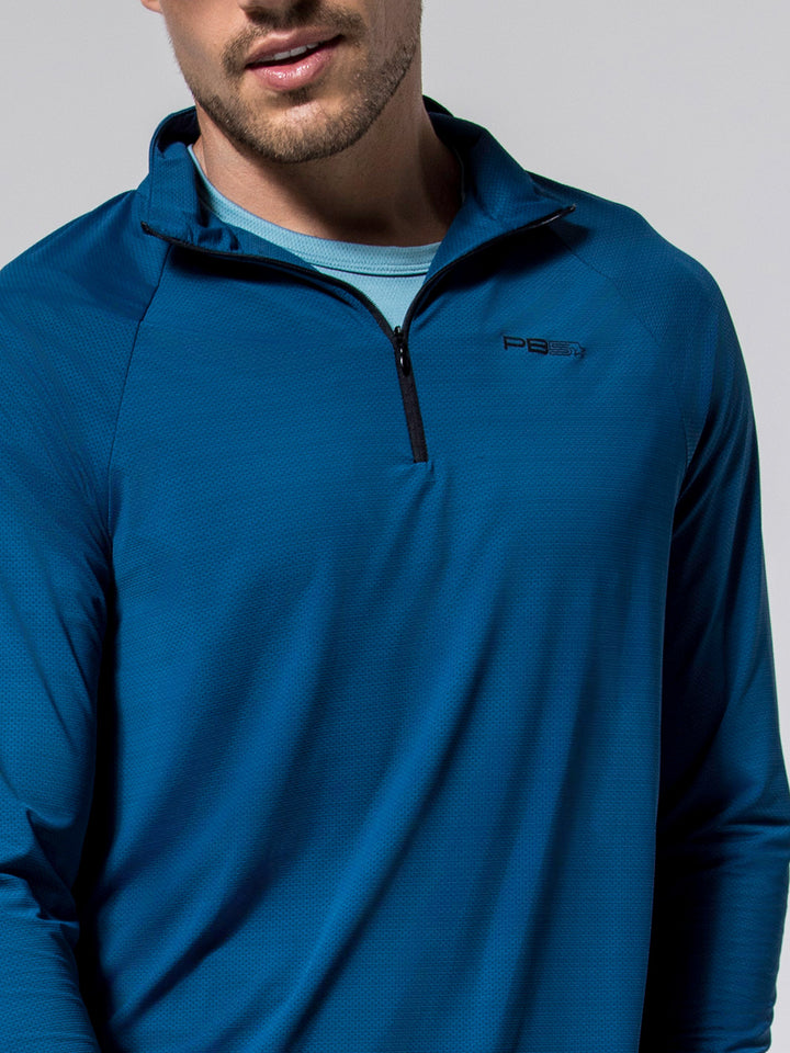 Close-up of man wearing astral blue M's Layering Tee with quarter zip collar and PB5 logo on chest.