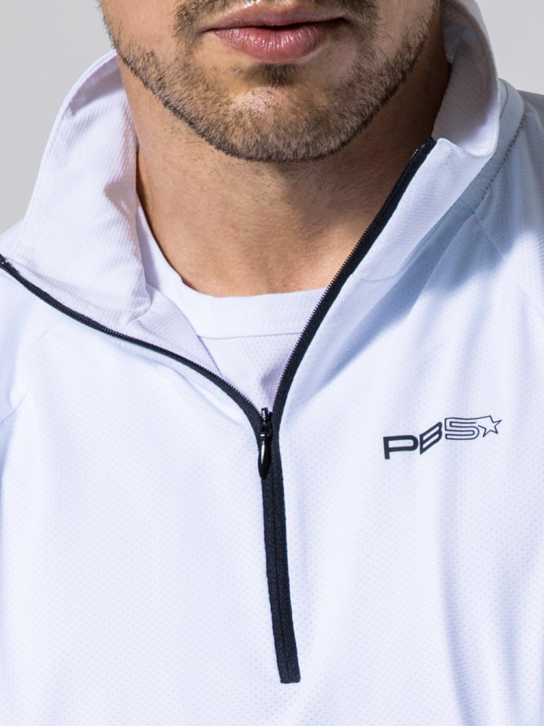 Close-up of man wearing white M's Layering Tee with zip collar and PB5 logo on chest.