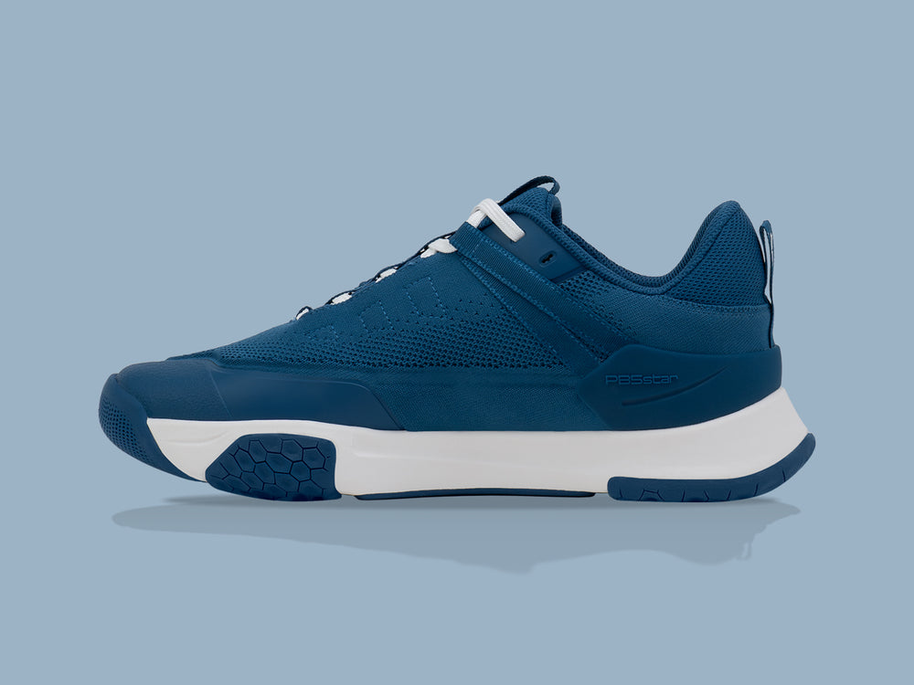 Side view of the PB5 Court2 athletic shoe in Astral Blue with PB5star branding, showcasing a cushioned sole, hexagonal traction design, and breathable knit upper.