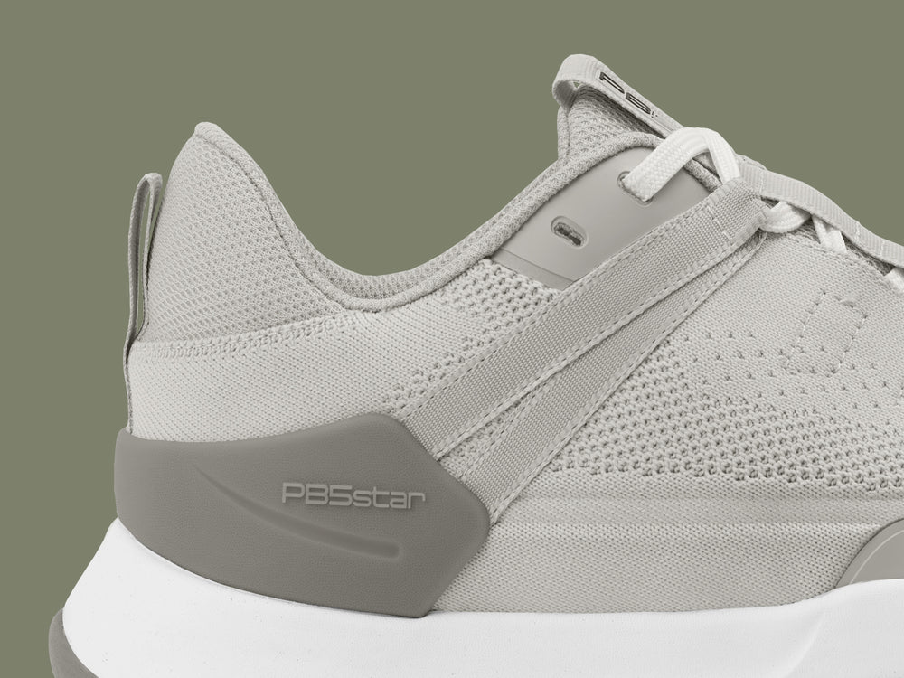 Close-up of PB5 Court2 athletic shoe in light grey with PB5star branding, highlighting the breathable knit upper and supportive heel design.