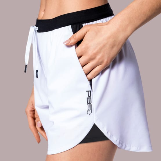 Close up of a woman wearing Pb5star Signature Court Short in white and black, designed for active wear and comfort.