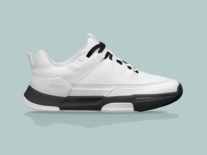 Side view of the PB5 Court2 white and black athletic shoe with PB5star branding, black laces, dynamic stability assist technology, and a black cushioned sole.