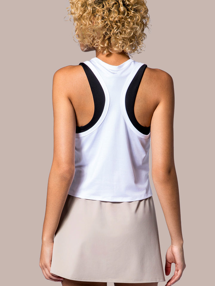 Rear view of a white PB5Star Cropped Racer Back Tank, paired with a the Lightweight Skirt in soft clay, highlighting the sporty back design.