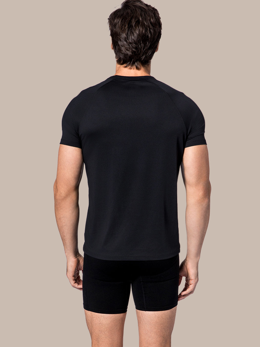 Rear view of model wearing men's black compression shorts, designed for optimal pickleball performance.
