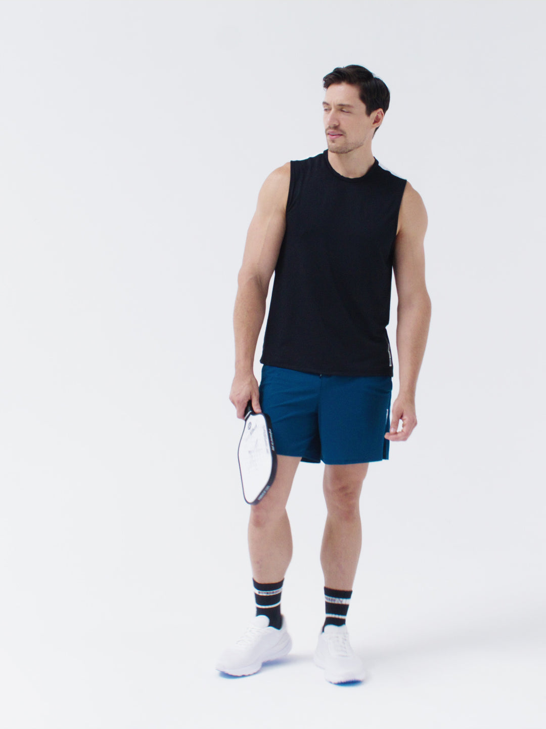 Video of male model showcasing PB5star Core Sleeveless Tee in black and Signature Court Short in astral blue, holding a PB5star pickleball paddle.