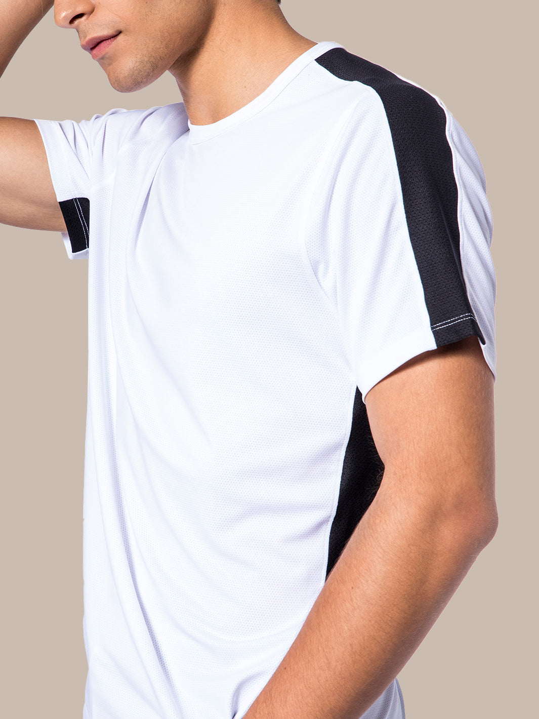 Side view of a model in PB5Star's men's Core Vented Tee in white with black mesh panels for breathability during workouts.