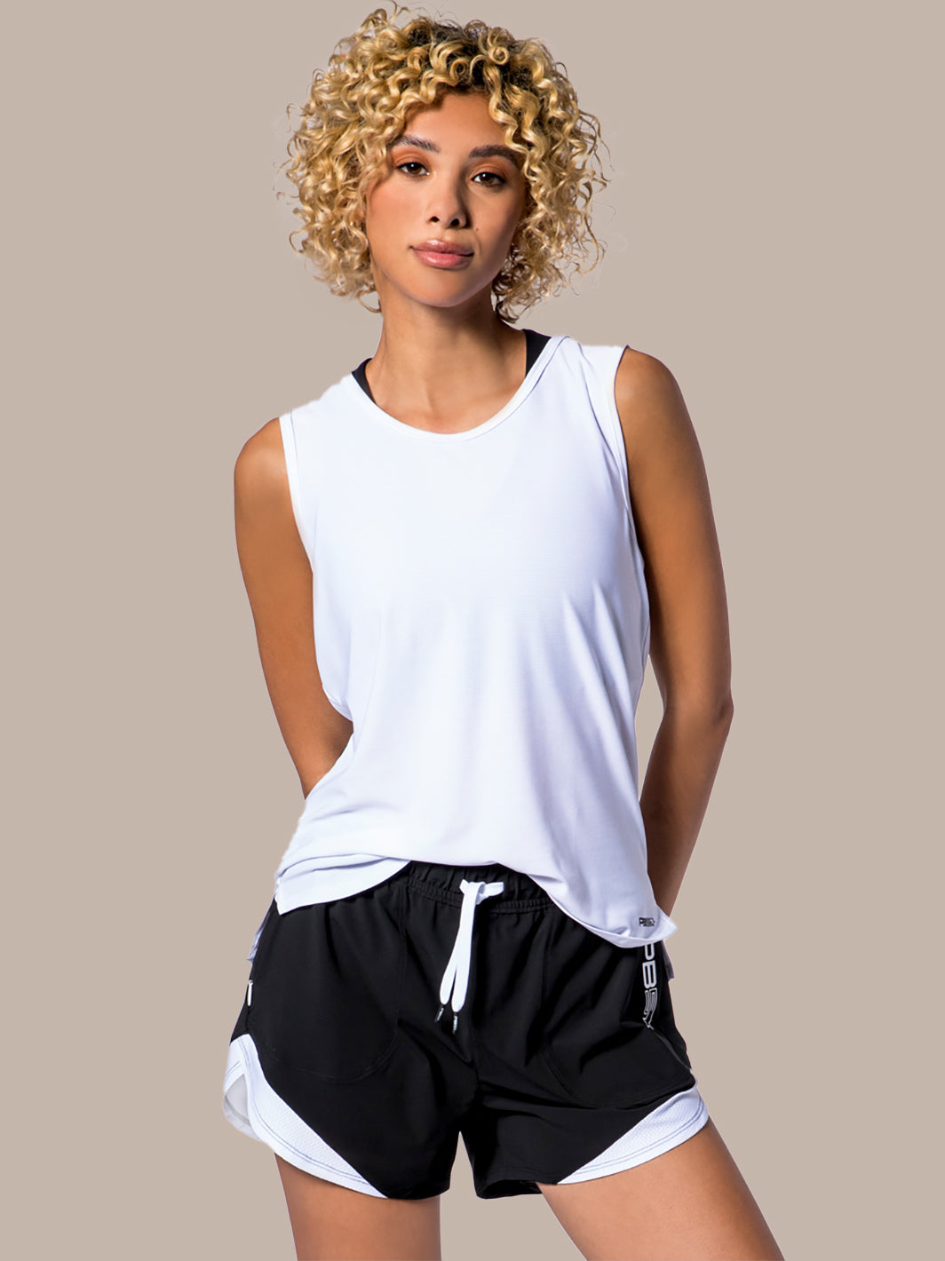 Model wearing PB5star's women's Vented Tank in white and black, paired with matching Vented Court Shorts, featuring a relaxed fit and breathable design for optimal performance and style on the pickleball court.